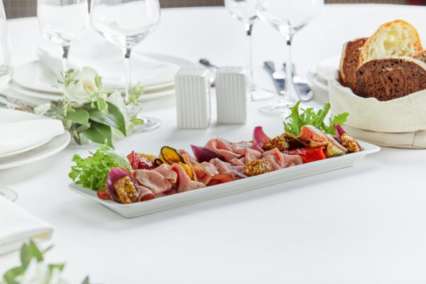 Sliced Beef or Pork with Marinated Vegetables and Sauce. Beautifully decorated catering banquet menu. Food snacks and appetizers for buffet. on white background