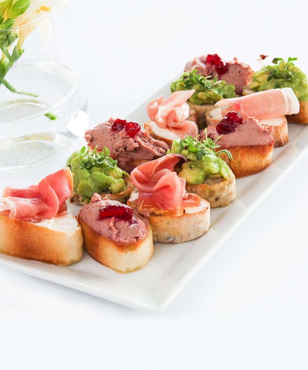 zblizenie bruschettas w talerzu na bialym stole pod swiatlami scaled