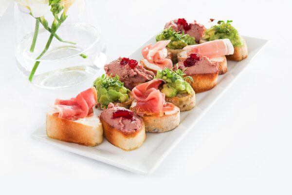 A closeup of Bruschettas in a plate on the white table under the lights